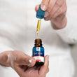 Load image into Gallery viewer, A hand holding a bottle of olive oil ear drops bottle and dropper
