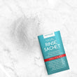 Load image into Gallery viewer, An opened nasal rinse sachet with its contents spilled beside it
