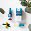 Load image into Gallery viewer, Olive oil ear drops bottle, its dropper, its retail box, and with olive oil in the background