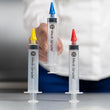 Load image into Gallery viewer, 3 Medi Grade Earwax Removal Syringes on a table while the middle ear syringe is being picked up by a person