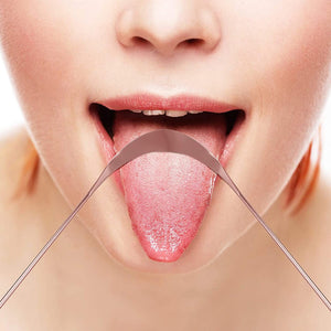 A closeup of a woman cleaning her tongue with a copper tongue scraper