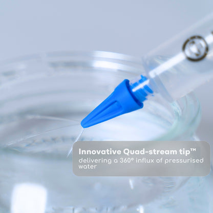 Blue quad-stream tip delivering pressurized water with a blurred background